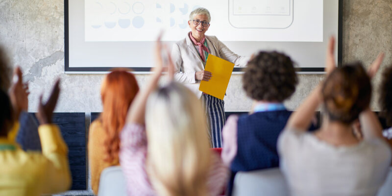 Group of young creative people in a pleasant atmosphere in the office is clapping to a lecture held by their boss