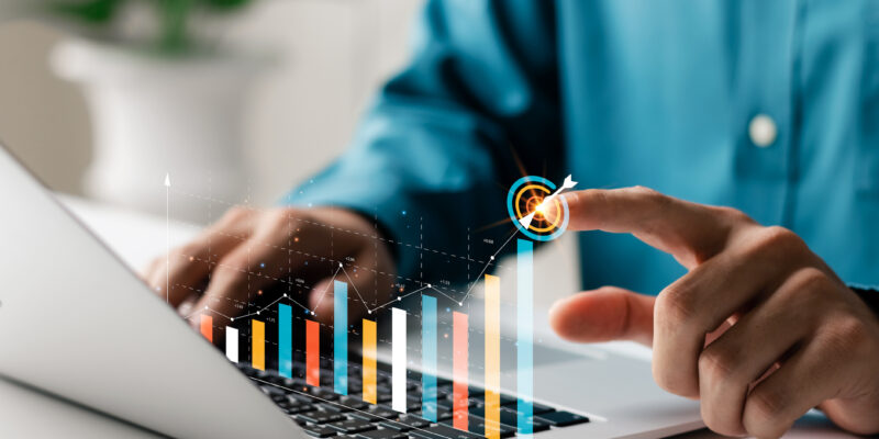 Businessman analyzing company's financial balance sheet working with digital augmented reality graphics. Businessman calculates financial data for long-term investment.