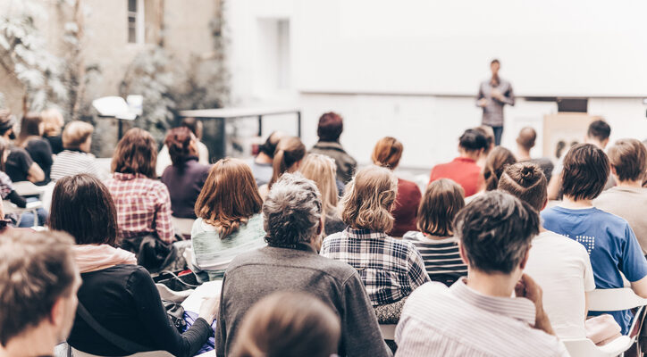 Rear View Of People Sitting In Auditorium
