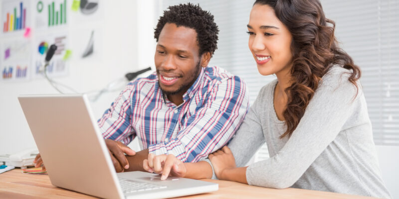 Young smiling business people in front of the laptop in the office