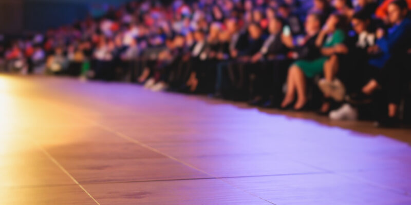 Audience at the modern conference hall listens to panel discussion, people on a congress together listen to speaker on stage at convention, business seminar, amphitheater venue for congress