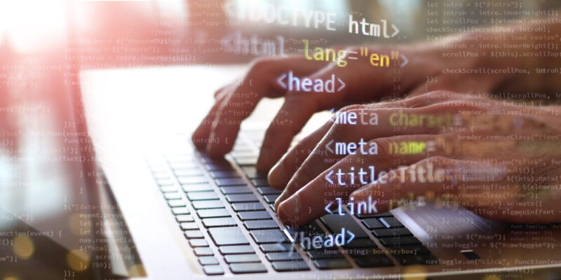 hands printing code on laptop. internet technology concept business front-end developing banner. mixed media background